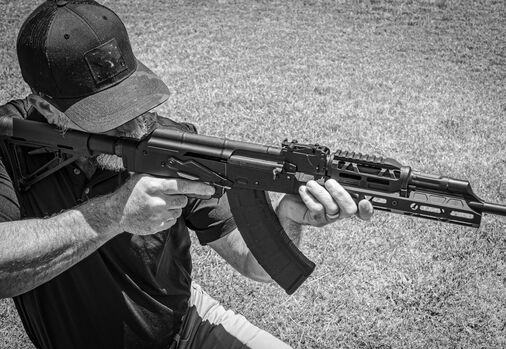 A man aiming an AK-47 rifle