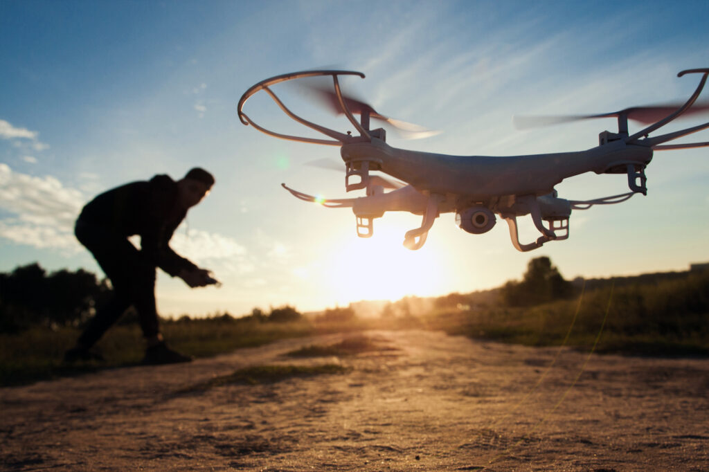A man is flying a drone in the sunset